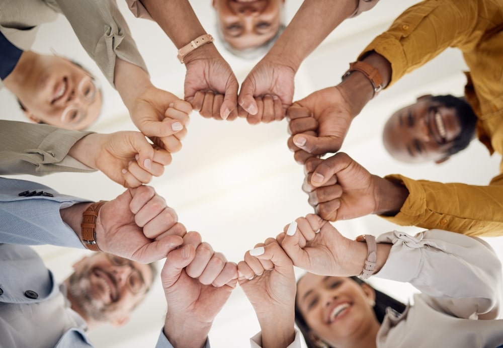 Group Of People Forming A Circle With Their Fists