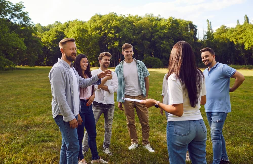 Group Of Young People Standing In A Field And Smiling